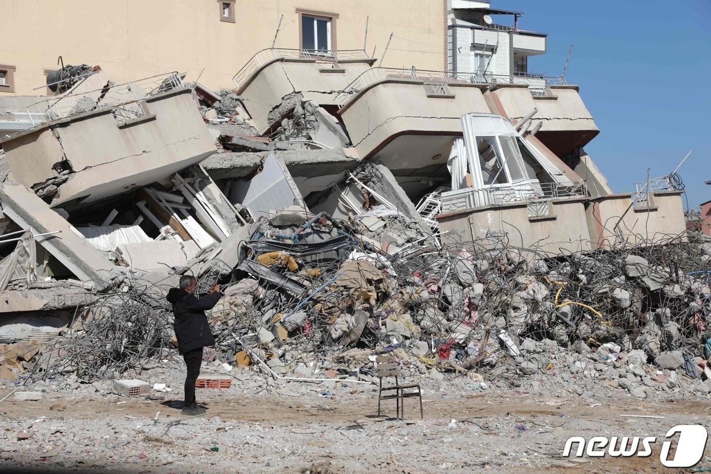 16일 (현지시간) 규모 7.8의 지진이 강타한 튀르키예 가지안테프에서 주민이 폭삭 무너진 건물의 사진을 찍고 있다. ⓒ AFP=뉴스1 ⓒ News1 우동명 기자