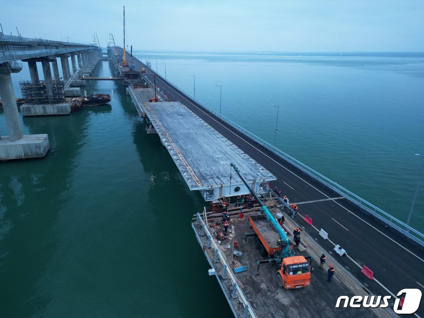 본문 이미지 - 26일(현지시간) 크림반도(크림반도)와 러시아 본토를 연결하는 크림대교 붕괴로 노동자들의 복구 작업이 한창이다. 크름대교는 아조우해와 흑해를 잇는 케르치해협에 위치해있다. 2023.1.26 ⓒ 로이터=뉴스1 ⓒ News1 정윤미 기자