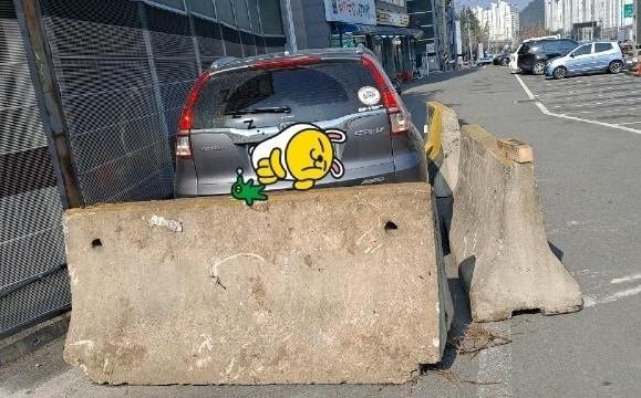 본문 이미지 - 창원의 한 고깃집을 찾은 손님이 갓길에 주차를 했다가 건물주의 횡포로 차를 사용하지 못하고 있다. 건물주는 "내 땅"이라며 지게차를 이용해 콘크리트 구조물로 손님의 차를 가둬둔 상태다. ('보배드림' 갈무리)