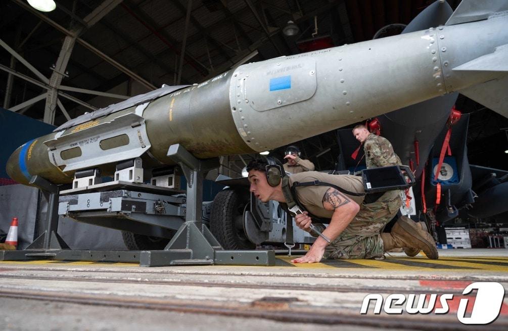 본문 이미지 - 2018년 7월15일(현지시간) 미국 알래스카 엘멘도르프-리처드슨 합동 기지에서 한 병사가 GBU-32 통합직격탄(JDAM)을 F-22 랩터 전투기로 옮기고 있다. (미 공군 홈페이지 갈무리)
