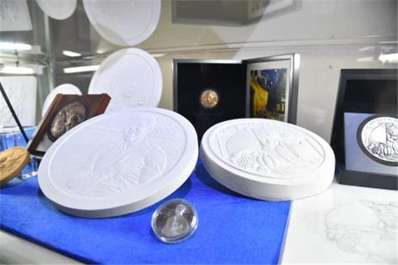 본문 이미지 -  기념메달 및 석고 조각이 함께 전시되어 있다.