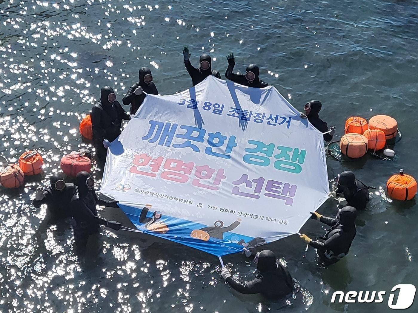 본문 이미지 - 22일 오전 부산 기장군 연화리 바다에서  신암어촌계 해녀들이 '청정바다 클린선거' 퍼포먼스를 펼치고 있는 모습(부산시선거관리위원회 제공).