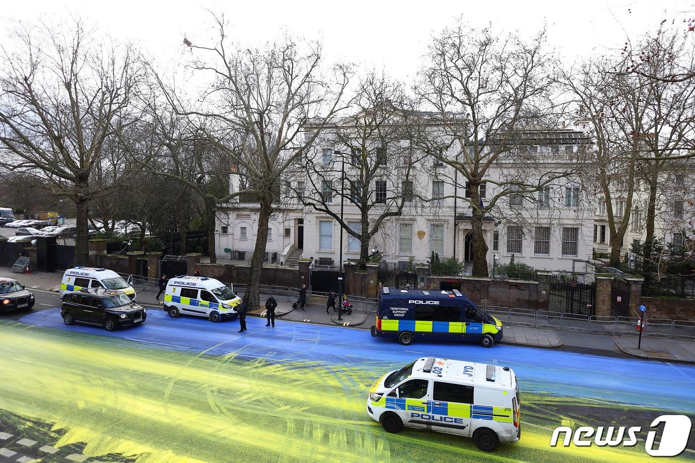 본문 이미지 - 23일(현지시간) 영국 런던 주재 러시아 대사관 앞 도로에 한 시민단체가 우크라이나를 상징하는 '파랑·노랑 빛깔' 페인트를 칠했다. 2023.02.23. ⓒ 로이터=뉴스1 ⓒ News1 김성식 기자