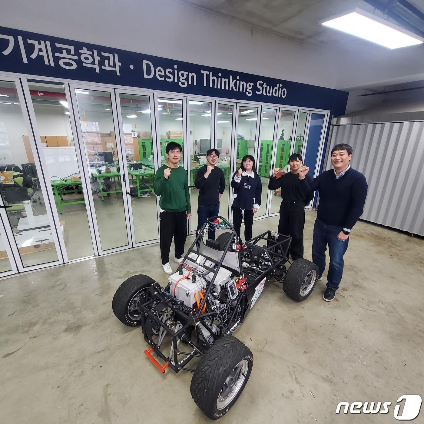 본문 이미지 - 조구영 기계공학과 교수가 학생들이 제작한 자동차의 엔진, 소재, 장비 테스트를 마치고 기념촬영을 하고 있는 모습.(단국대 제공)