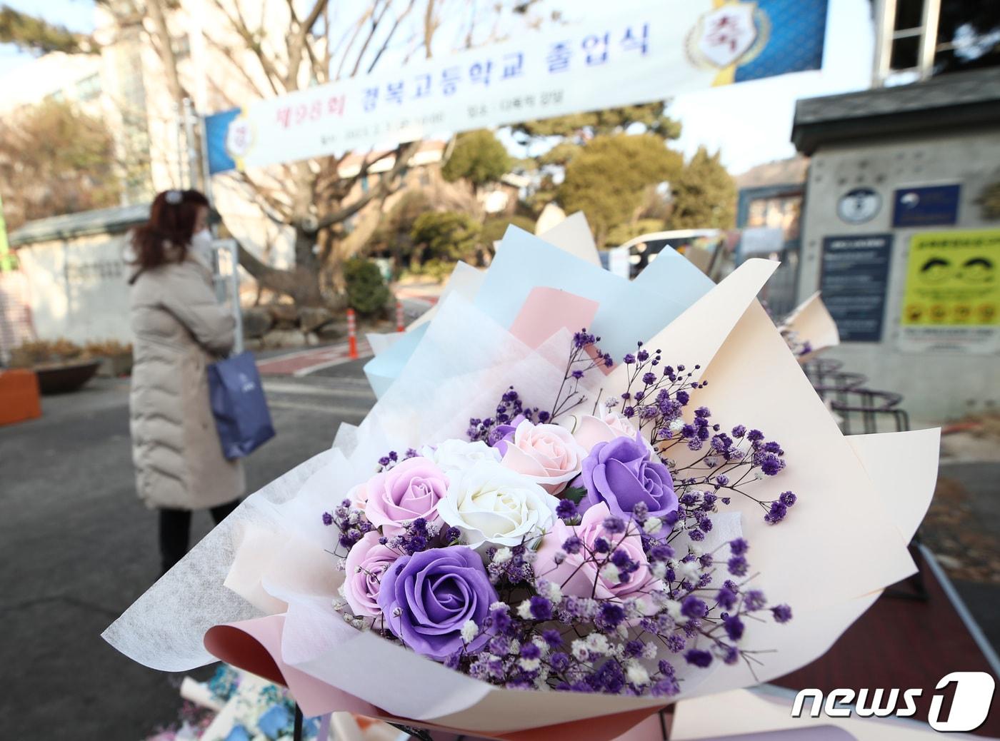 본문 이미지 - 3일 오전 제98회 졸업식이 열린 서울 종로구 경복고등학교 앞에서 한 상인이 꽃다발을 팔고 있다. 졸업식과 입학식 시즌을 앞두고 실내 마스크 해제로 대목을 기대했던 꽃집과 화훼 농가들은 신종 코로나바이러스 감염증(코로나19) 여파로 화훼 농사를 접은 농가의 증가와 등유 가격 상승으로 난방비가 치솟으며 생화 가격이 올라 어려움을 겪고 있다. 2023.2.3/뉴스1 ⓒ News1 김민지 기자