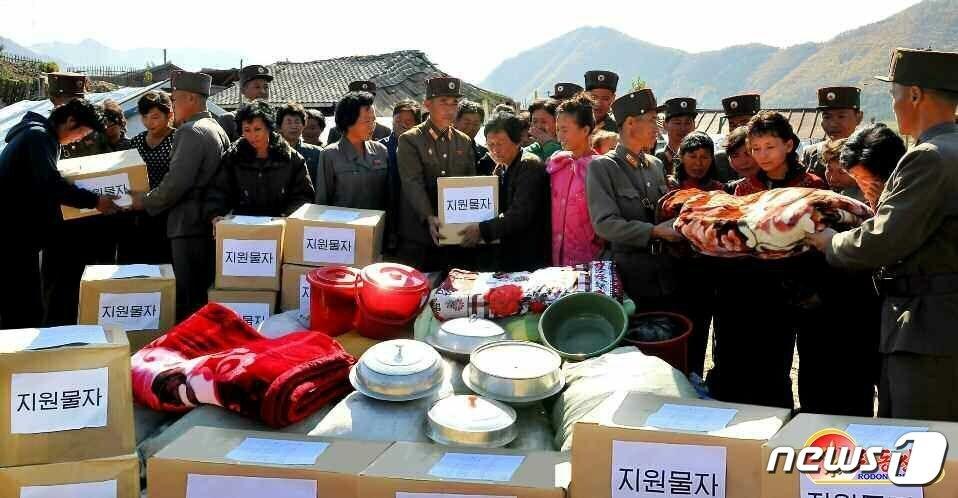 본문 이미지 - (평양 노동신문=뉴스1) = 북한 군인들이 인민들에게 지원물자를 전달하고 있다. (사진은 기사 내용과 무관함) [국내에서만 사용가능. 재배포 금지. DB 금지. For Use Only in the Republic of Korea. Redistribution Prohibited] rodongphoto@news1.kr