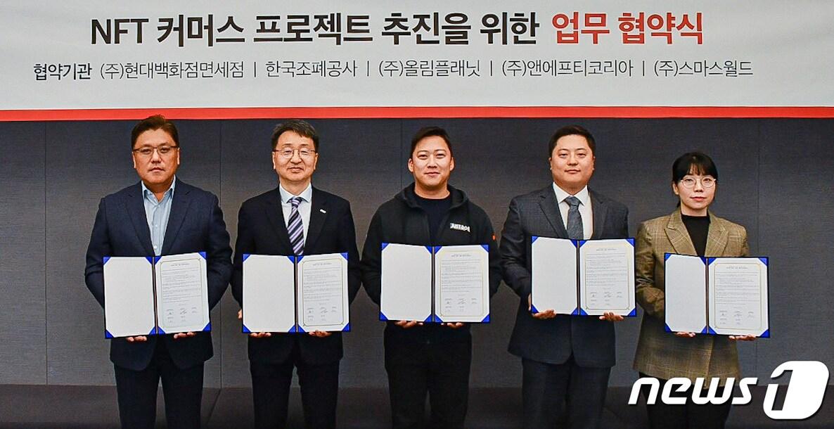본문 이미지 - (사진 왼쪽부터)육우석 현대백화점면세점 마케팅담당 상무, 임도현 한국조폐공사 ICT이사, 권재현 올림플래닛 대표, 임종령 앤에프티코리아 대표, 허현 스마스월드 대표가 10일 서울 파르나스타워 올림플래닛 본사에서 NFT 커머스 프로젝트 추진을 위한 다자간 업무협약을 맺고 기념촬영을 하고 있다(현대백화점그룹 제공).