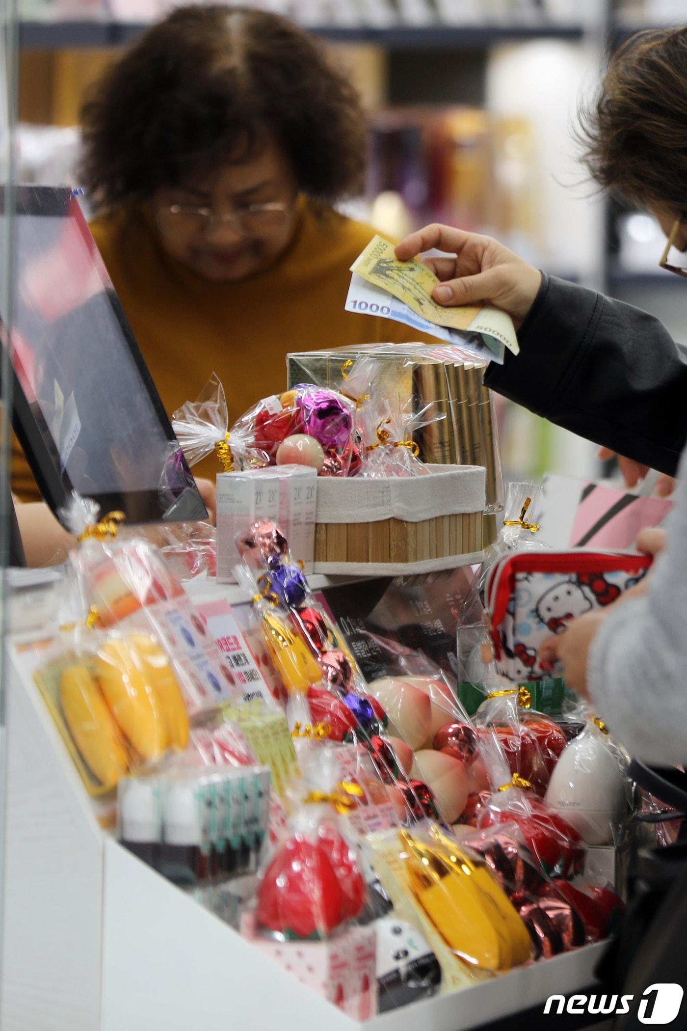본문 이미지 - 10일 오후 서울 중구 명동거리의 한 화장품 가게에서 외국인 관광객들이 쇼핑을 하고 있다.  2023.3.10/뉴스1 ⓒ News1 황기선 기자