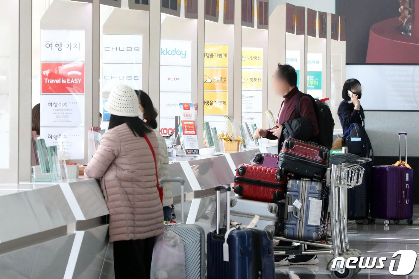 본문 이미지 - 인천국제공항 출국장 여행사 카운터에서 여행객이 안내를 받고 있다.  2023.3.13/뉴스1 ⓒ News1 황기선 기자