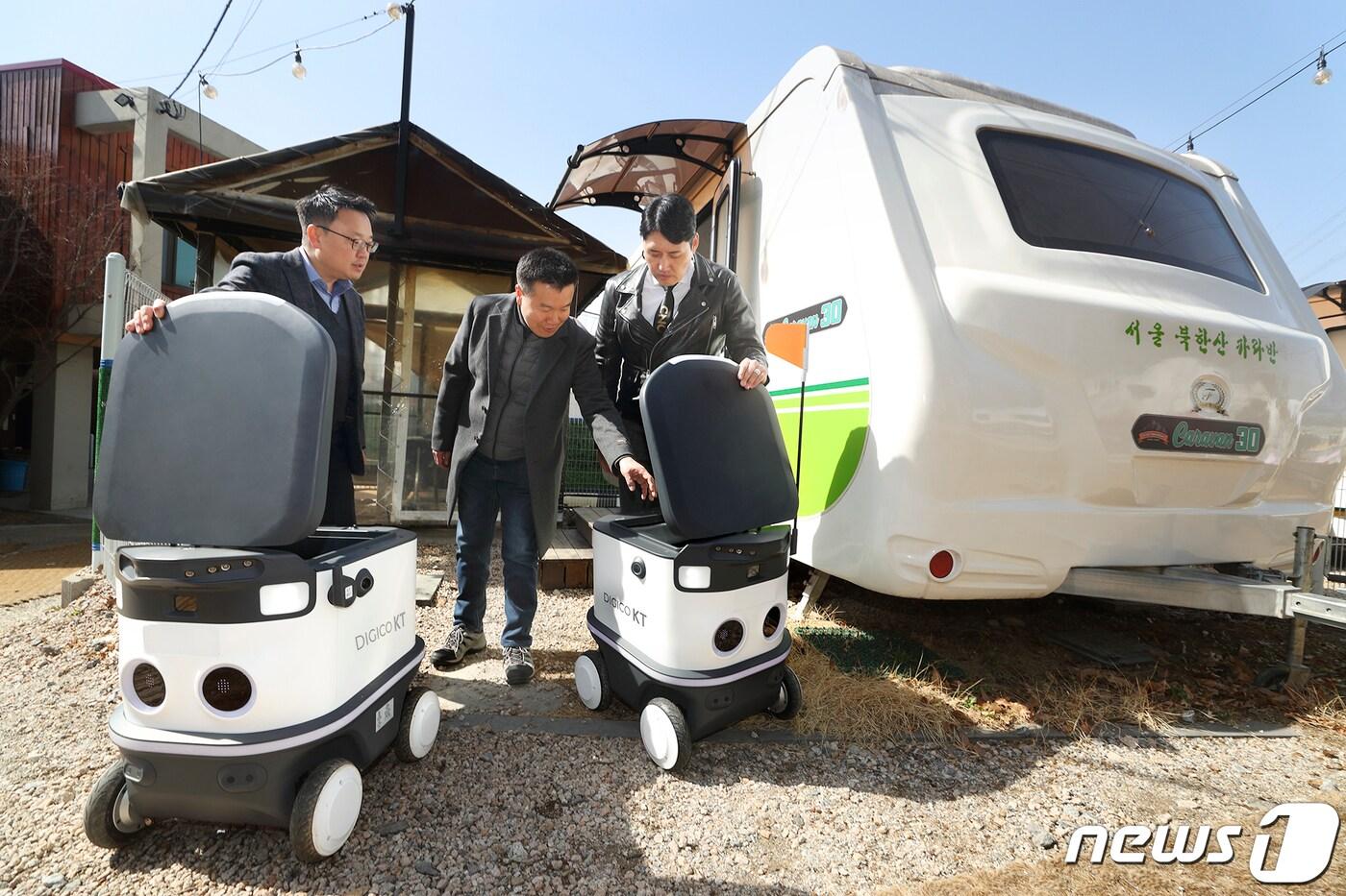 이상호 KT AI 로봇사업단 단장과 최종석 캠핑톡 대표, 김정환 캠핑아웃도어 대표가 KT 자율주행 배송로봇을 살펴보고 있다. (KT 제공) 2023.3.14/뉴스1