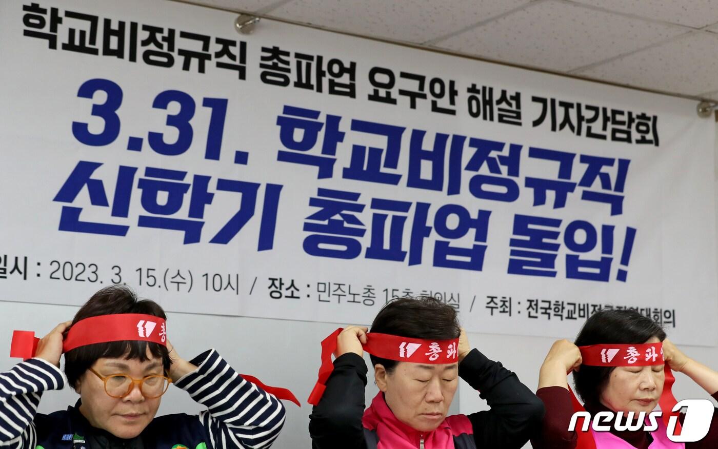 본문 이미지 - 학비연대 조합원들이 15일 민주노총에서 기자회견을 하던 도중 총파업 머리띠를 묶고 있다. 2023.3.15/뉴스1 ⓒ News1 장수영 기자