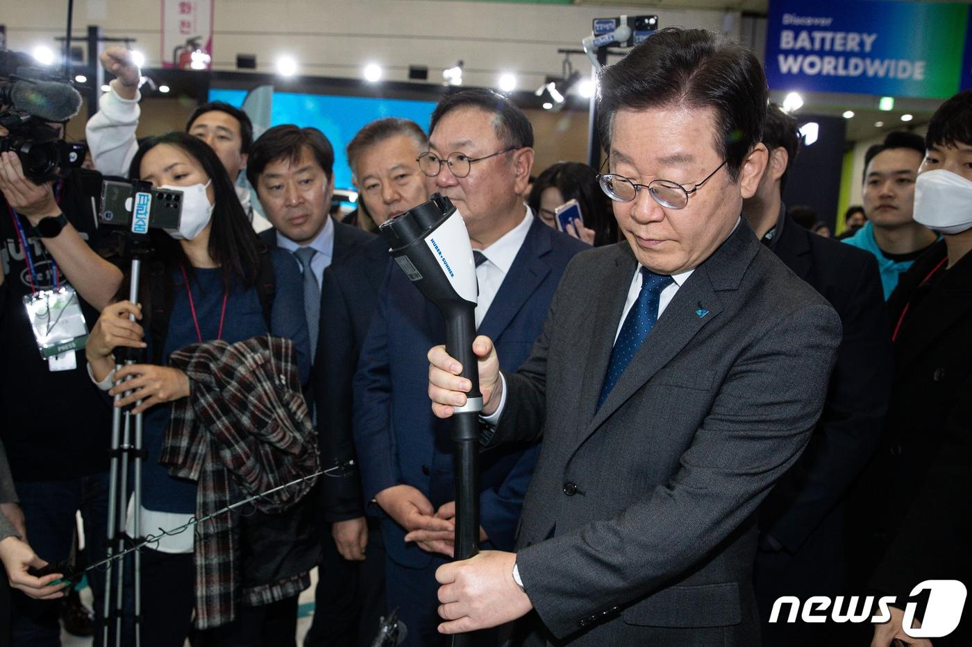 본문 이미지 - 이재명 대통령이 더불어민주당 당 대표 시절이던 2023년 서울 강남구 코엑스에서 열린 EV트렌드코리아에 참석해 전기차 충전 서비스 업체 부스에서 충전케이블을 만져보고 있다. 2023.3.16 ⓒ 뉴스1 유승관 기자
