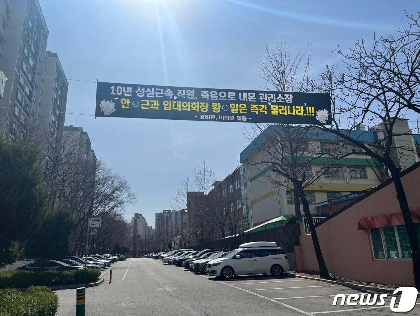 본문 이미지 - 지난 15일 경비원이 극단적 선택을 한 서울 대치동 아파트 단지에 현수막이 걸려있다.ⓒ 뉴스1