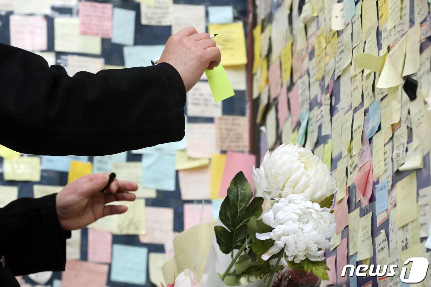 아카시시(市) 유가족 미키 기요시씨가 서울 용산구 이태원 참사 현장에서 희생자를 위한 메시지를 붙이고 있다. 아카시시 압사 사고는 2001년 일본 효고현 아시시시 육교에서 일어난 대형 사고로 불꽃 축제 중 인파가 한 데 몰려 발생한 참사다. 2023.3.17/뉴스1 ⓒ News1 황기선 기자