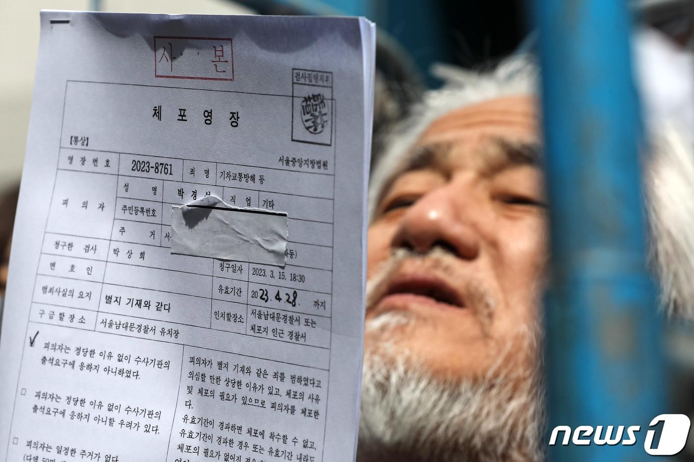 본문 이미지 - 박경석 전국장애인차별철폐연대(전장연) 대표가 17일 오전 서울 종로구 서울지방경찰청 앞에서 법원의 체포영장 발부에 따른 입장발표 기자회견을 마치고 체포영장을 받아들고 있다. 2023.3.17/뉴스1 ⓒ News1 이승배 기자