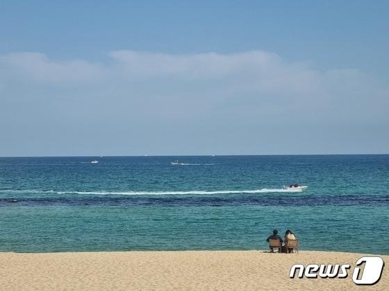본문 이미지 - 완연한 봄 날씨를 보인 지난 18일 강원 강릉 안목커피해변에서 나들이객 앞으로 모터보트가 지나가고 있다./뉴스1 윤왕근 기자