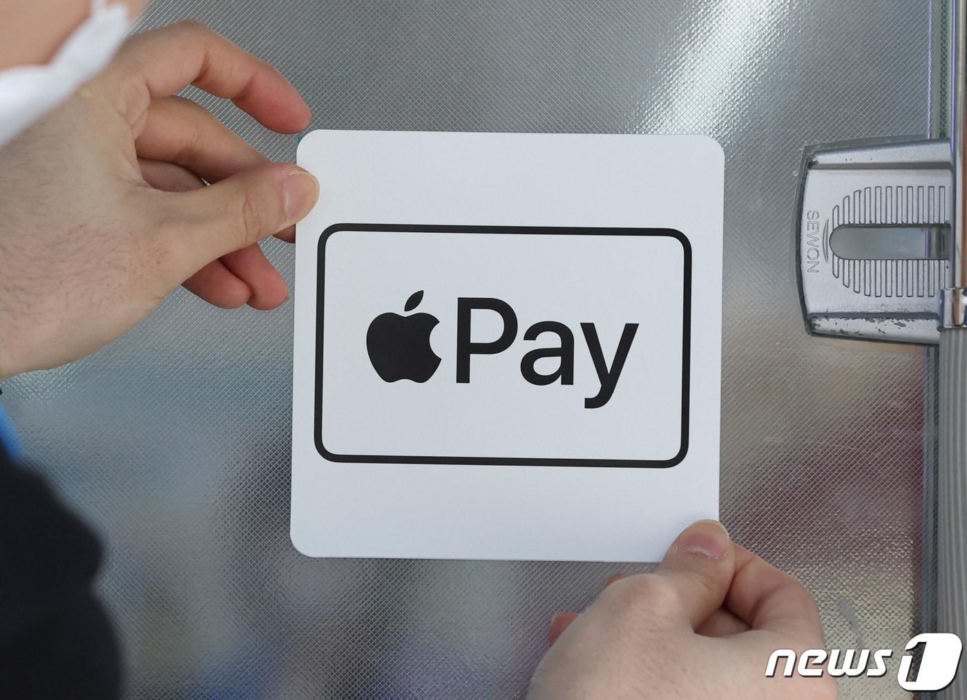 본문 이미지 - 21일 서울 강남구 GS25 역삼홍인점에서 직원이 애플의 간편 결제 서비스 &#39;애플페이&#39; 안내문을 게시하고 있다. 2023.3.21/뉴스1 ⓒ News1 구윤성 기자