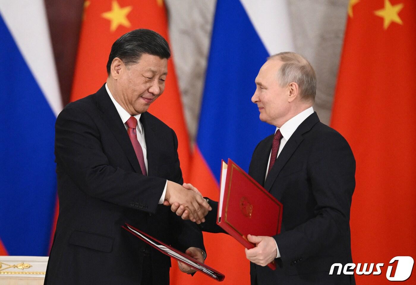 본문 이미지 - 시진핑 중국 국가주석과 블라디미르 푸틴 러시아 대통령이 21일(현지시간) 러시아 모스크바 크렘린궁에서 정상회담을 마치고 서명식에서 악수를 하고 있다. 2023.3.21 ⓒ 로이터=뉴스1 ⓒ News1 정윤미 기자