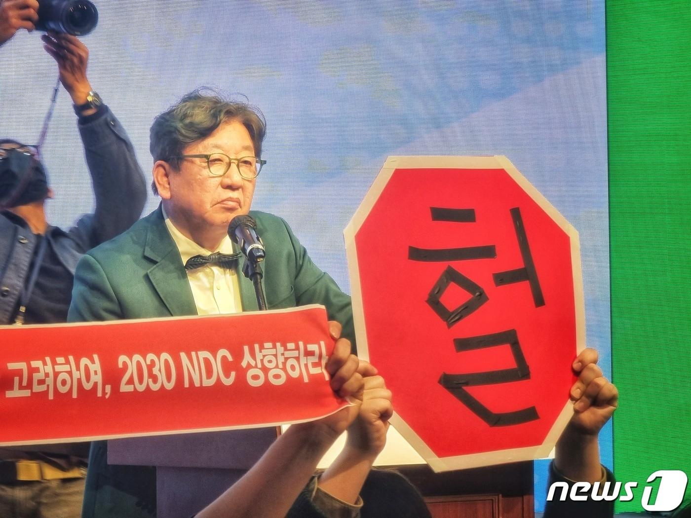 본문 이미지 - 김상협 2050 탄소중립녹색성장위원회 민간위원장이 국가 탄소중립 녹색성장 기본계획 수립 등에 대한 공청회에서 발언하는 도중 환경단체들이 2030 국가온실가스감축목표 상향을 주장하며 기습시위를 벌이고 있다. 2023.3.22/뉴스1 ⓒ News1 황덕현 기후환경전문기자