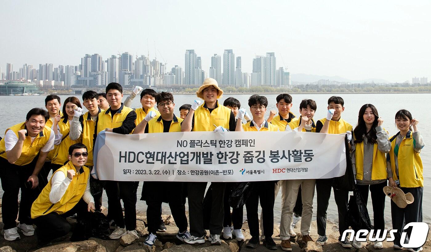 본문 이미지 - HDC현대산업개발 임직원들이 이촌-반포 일대 환경을 정비하기 위한 한강 줍깅 봉사활동에 참여해 기념사진을 촬영하고 있다..(HDC현대산업개발 제공). 