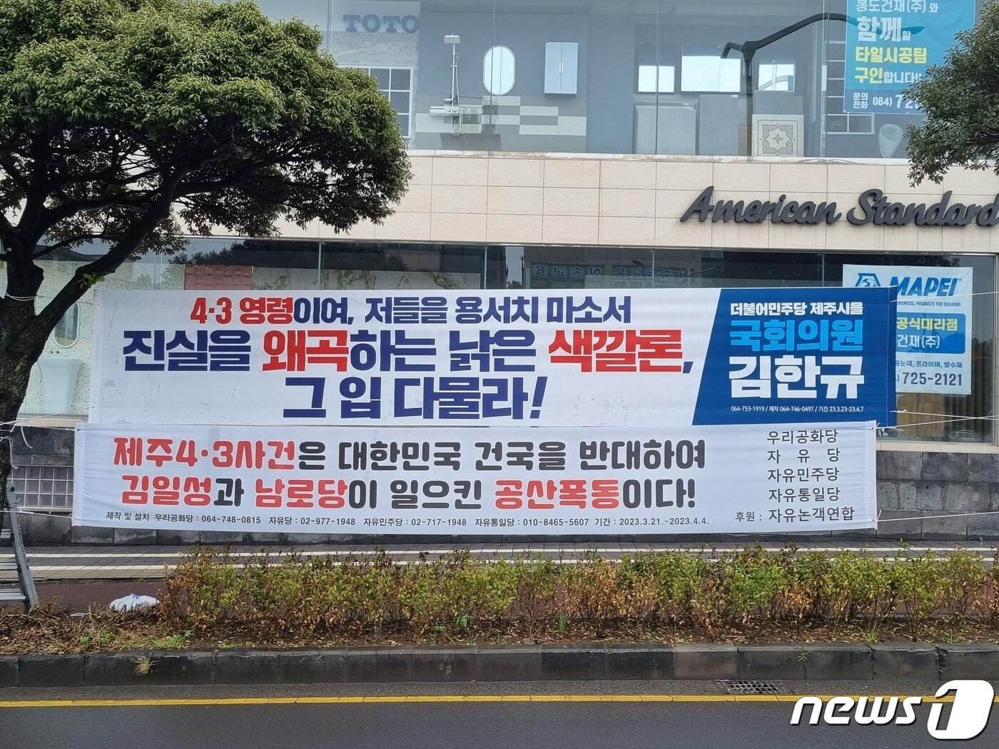 본문 이미지 - 제75주년 제주4·3추념식을 앞두고 제주에서 '4·3은 김일성이 주도한 공산폭동'이라는 내용의 현수막 등장으로 촉발한 갈등이 격화하고 있다. 우리공화당 등 보수진영과 김한규 국회의원이  각각 제주시내 한 도로에 설치한 현수막./뉴스1 