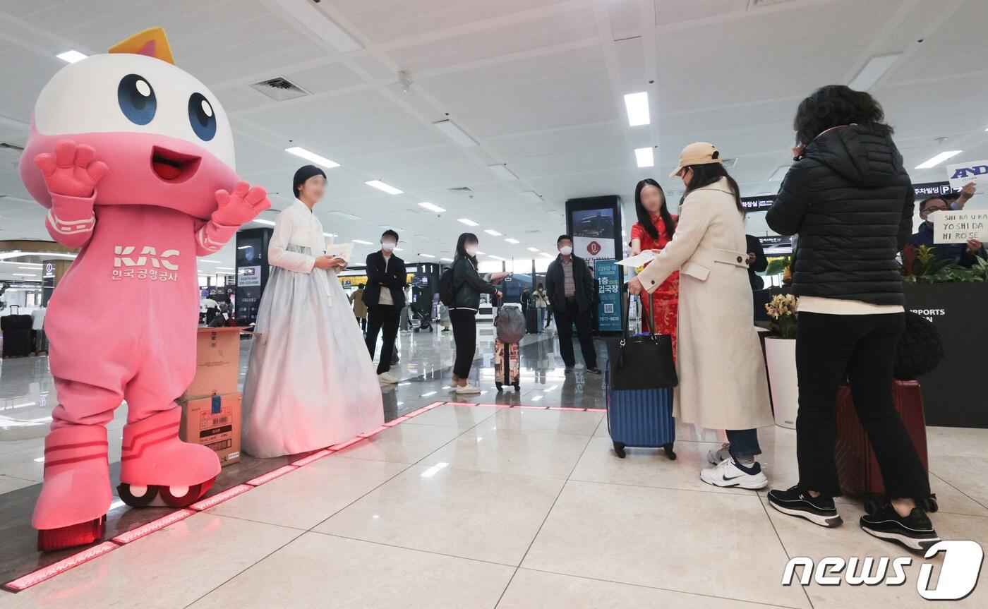 27일 오후 한국공항공사 관계자들이 김포공항에서 김포~베이징·상하이 노선 운항 재개를 기념해 입국하는 승객들에게 기념품을 나눠주고 있다. (공동취재) 2023.3.27/뉴스1 ⓒ News1 김민지 기자