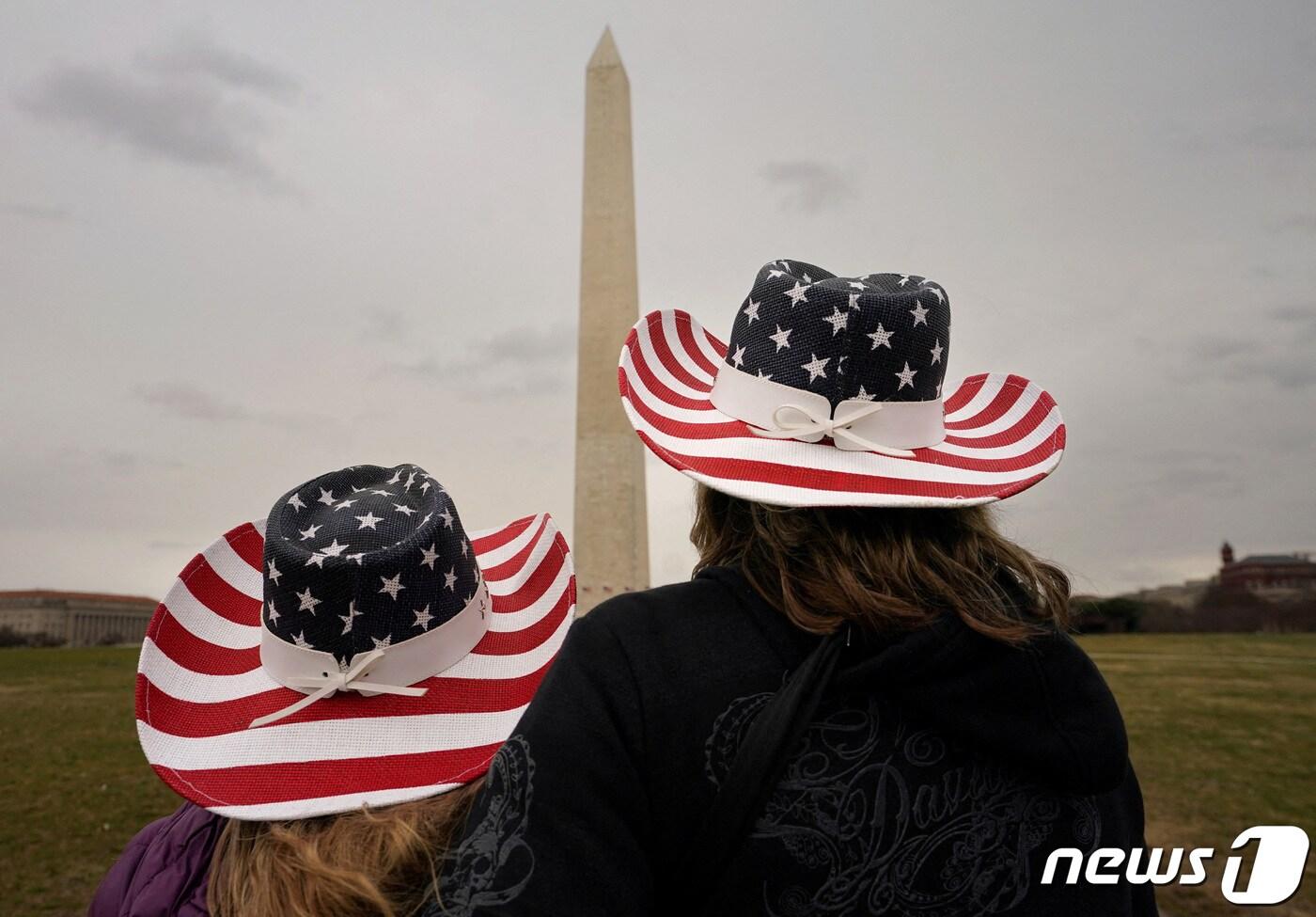 지난 1월 미국 워싱턴 DC에서 성조기 모양의 카우보이 모자를 쓴 관광객들이 미국을 건국한 조지 워싱턴을 기리는 워싱턴 기념탑을 바라보고 있다. 2023.01.17. ⓒ 로이터=뉴스1 ⓒ News1 김성식 기자