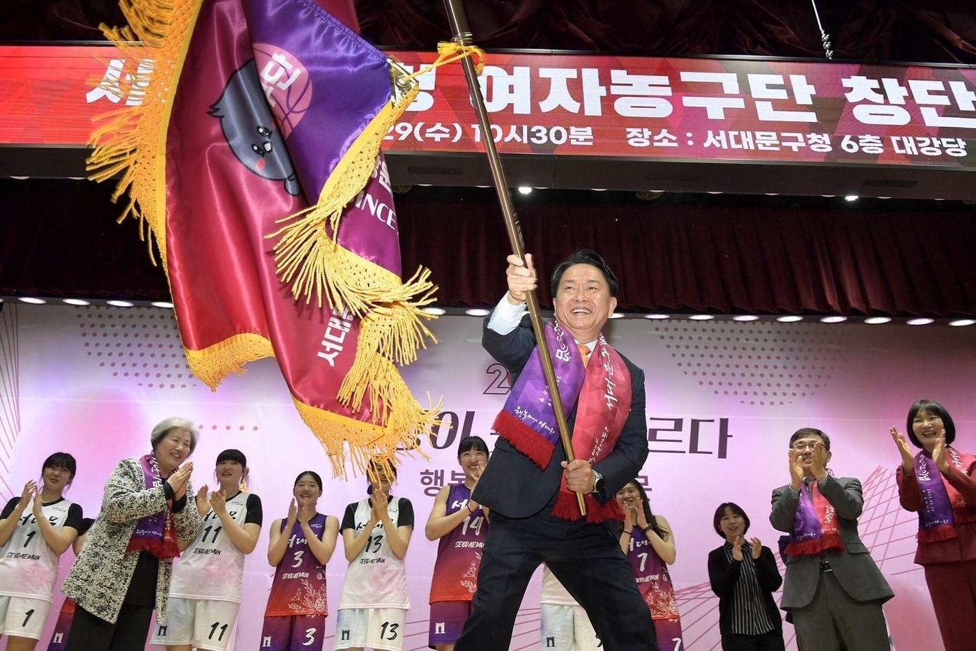 본문 이미지 - 이성헌 구청장이 서대문구청 여자실업농구단 창단식에서 구단기를 휘날리고 있다. (서대문구청 제공)