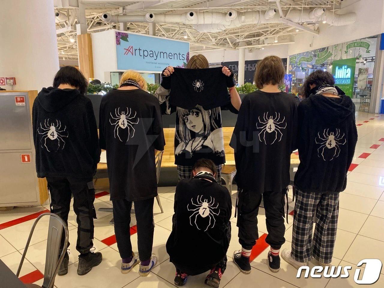 본문 이미지 - PMC 레단 회원을 상징하는 거미와 숫자 4가 그려진 검은 옷을 입은 이들의 모습.(트위터 갈무리).