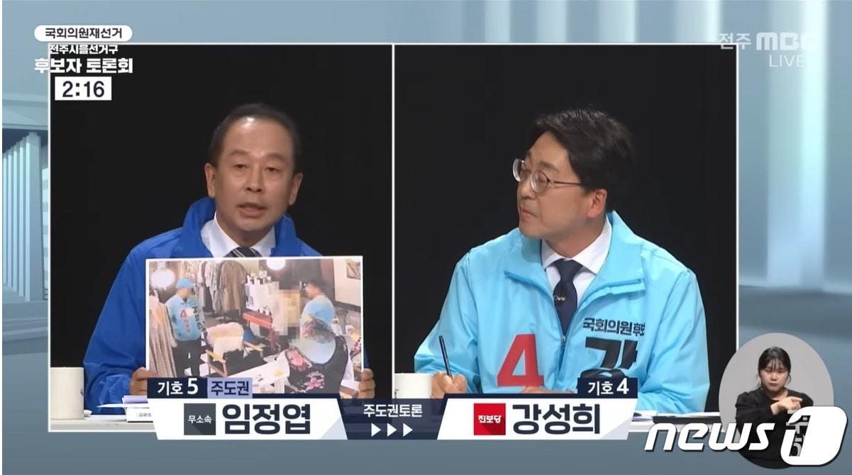 본문 이미지 - 지난 29일 전라북도선거관리위원회가 주최한 전주MBC 법정토론회에서 임정엽 후보(왼쪽)가 진보당 선거운동원의 사진을 공개하고 있다.(전주MBC 유튜브 캡쳐)2023.3.30/뉴스1