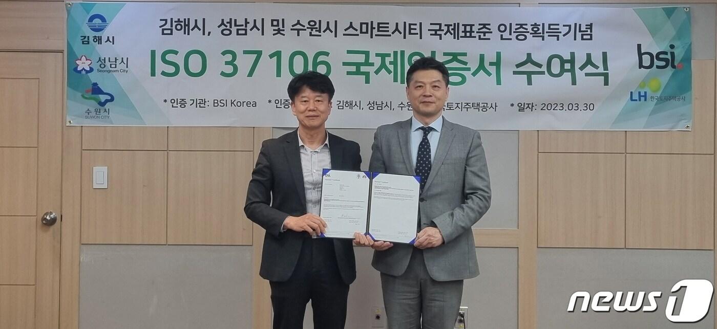 김종석 수원시 도시정책실장(왼쪽), BSI(영국표준협회) 임성환 대표이사가 스마트도시 국제표준(ISO37106) 인증서 수여식 후 기념촬영을 하고 있다.(수원시 제공)