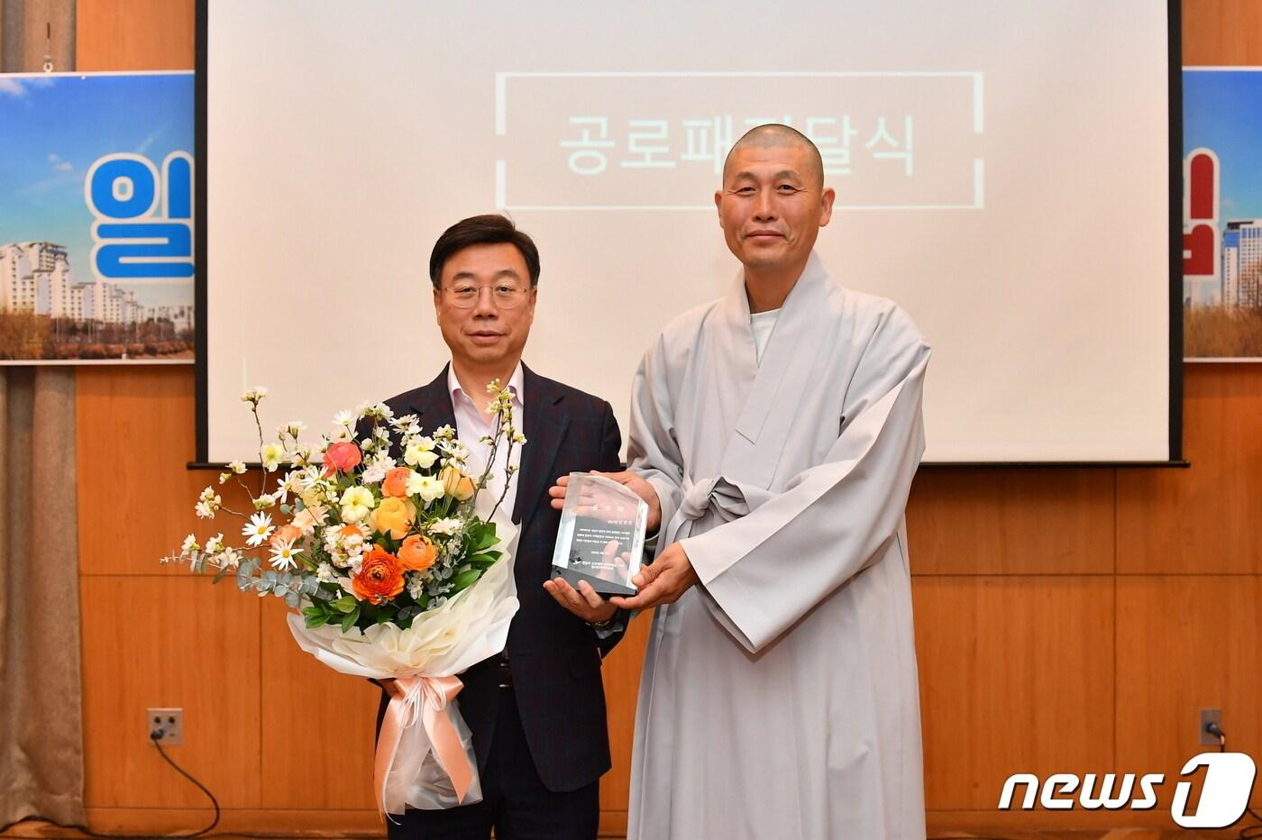 신상진 시장(왼쪽)이 과거 ‘성남시 고도제한 해결을 위한 범시민대책위원회’ 집행위원장을 맡아 고도제한 해결에 기여한 공로로 감사패를 받고 있다.(성남시 제공)