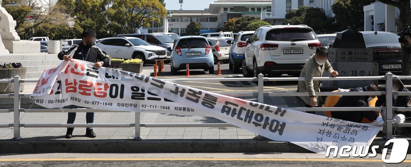 본문 이미지 - 31일 오전 제주시 직원들이 시청 인근에 게시된 '제주4·3 사건은 대한민국 건국을 반대하여 김일성과 남로당이 일으킨 공산폭동이다'라는 내용의 현수막을 철거하고 있다. .2023.3.31/뉴스1 ⓒ News1 고동명 기자
