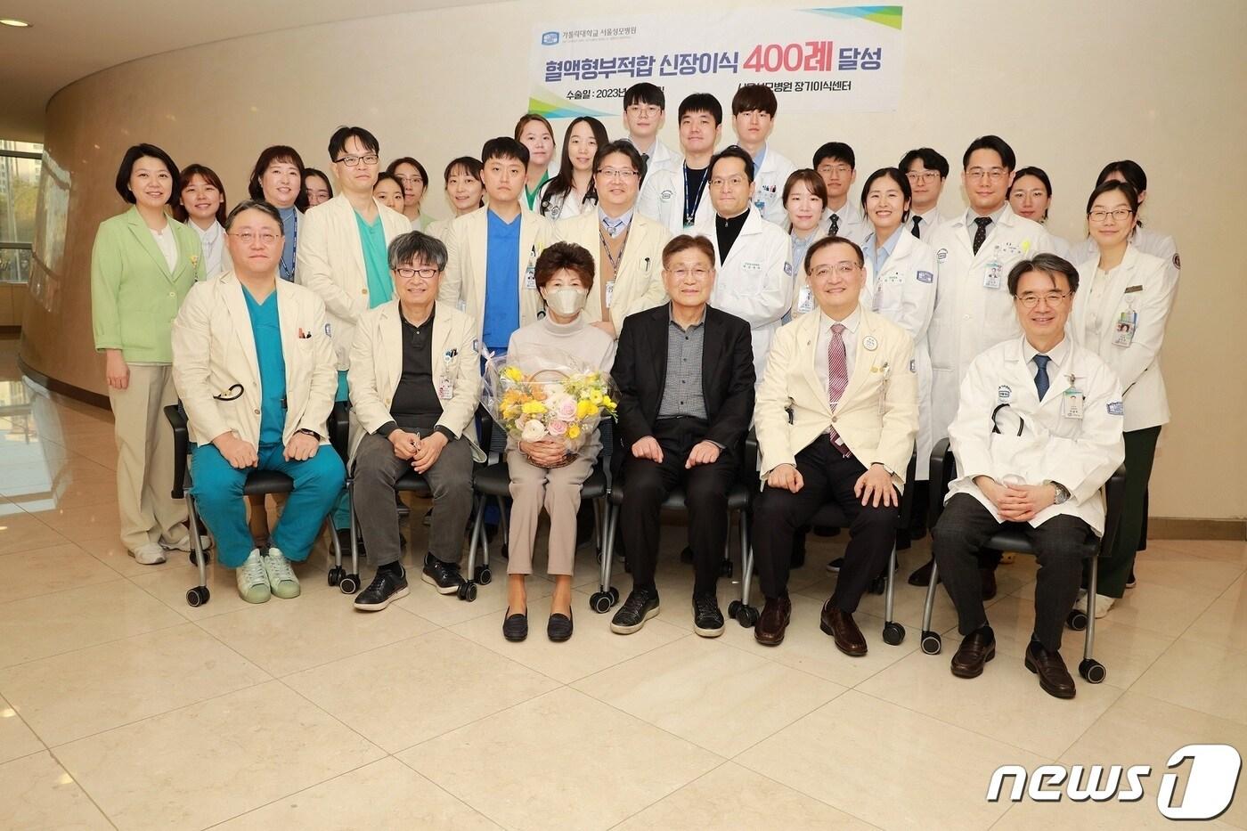 본문 이미지 - 400번째 혈액형 부적합 신장이식을 성공적으로 받은 환자와 장기이식센터 의료진이 기념촬영을 했다.(앞줄 맨왼쪽부터 박순철 장기이식센터장, 수술 집도의 혈관·이식외과 윤상섭 교수, 신장이식 환자와 남편, 주치의 신장내과 양철우 교수)/서울성모병원 제공