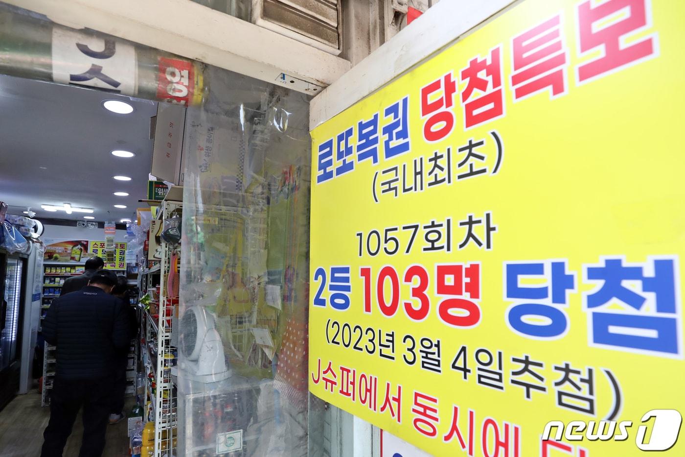 본문 이미지 - 서울 동대문구의 복권판매점에 '제 1057회차 로또복권 2등 103명 동시 당첨' 현수막이 걸려 있다. 지난 4일 제1057회 동행복권 로또 추첨 결과 2등은 664명 나왔다. 2023.3.7/뉴스1 ⓒ News1 황기선 기자