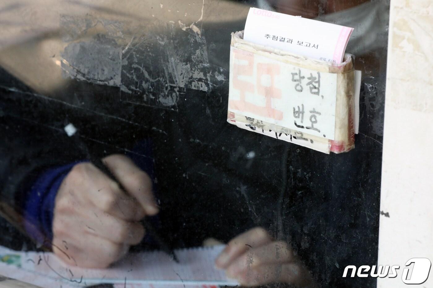 본문 이미지 - 서울 동대문구의 복권판매점에서 한 시민이 로또 번호를 기입하고 있다./뉴스1 ⓒ News1 황기선 기자