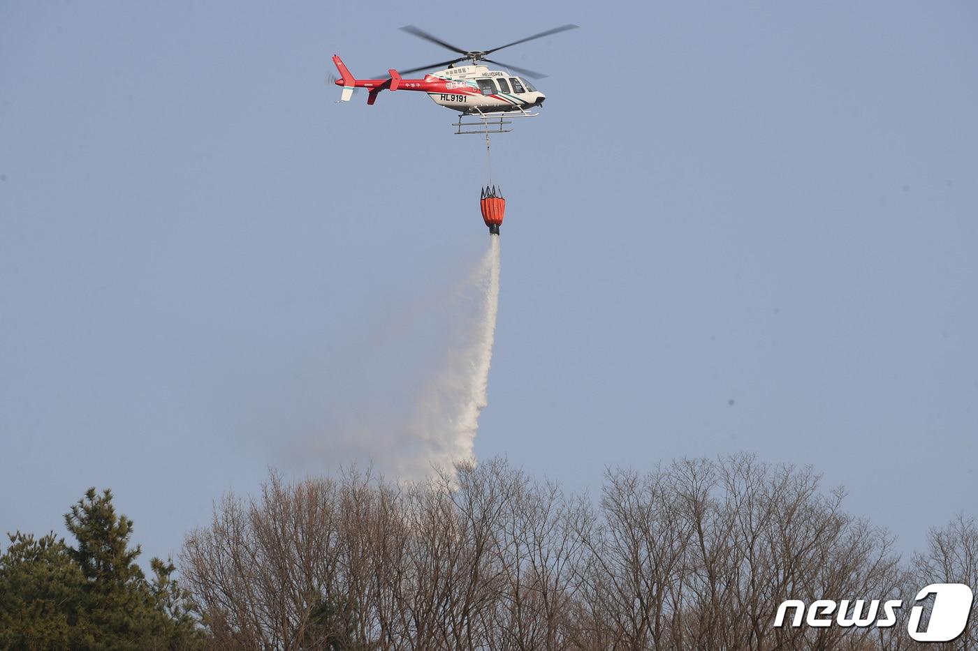 본문 이미지 - 산불현장에 출동한 헬기가 정상 부근에 물을 뿌리고 있다.(자료사진)/뉴스1 DB