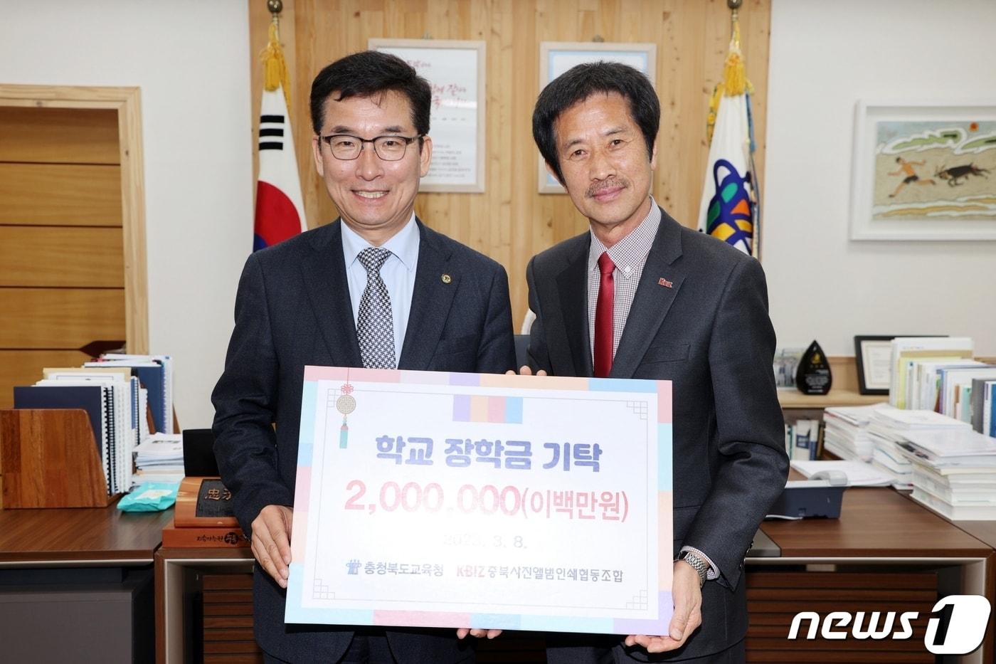 8일 오전 충북사진앨범인쇄협동조합 장광동 이사장(오른쪽)이 윤건영 충북교육감에게 장학금 200만원을 전달한 뒤 기념촬영을 하고 있다(충북교육청 제공) / 뉴스1