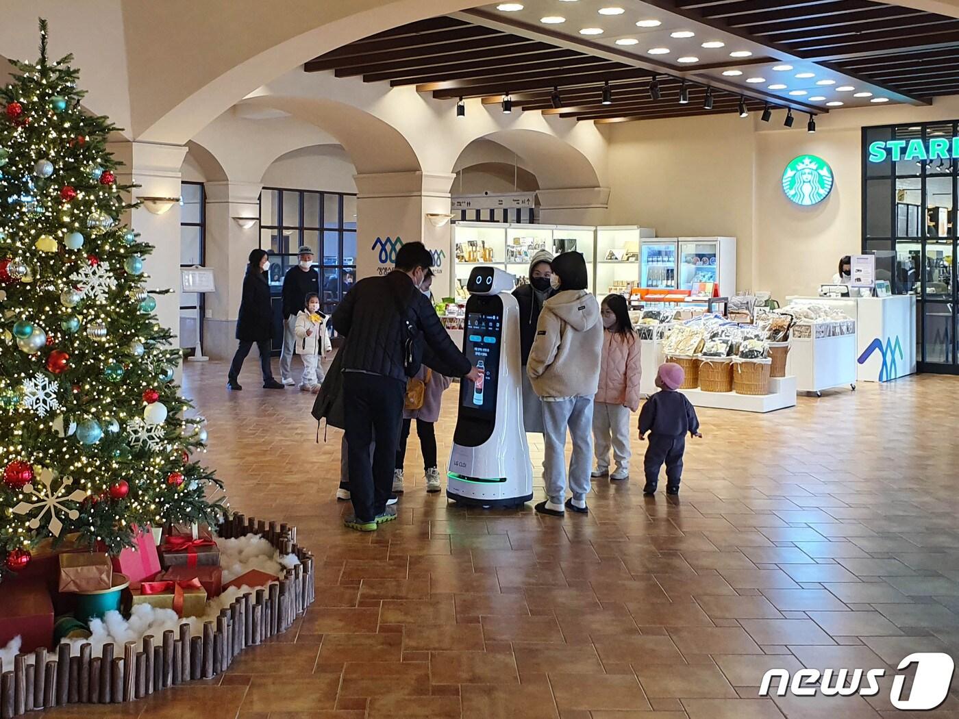 본문 이미지 - 한화리조트 설악 쏘라노에서 고객들이 로봇 서비스를 이용하는 모습(한화호텔앤드리조트 제공)