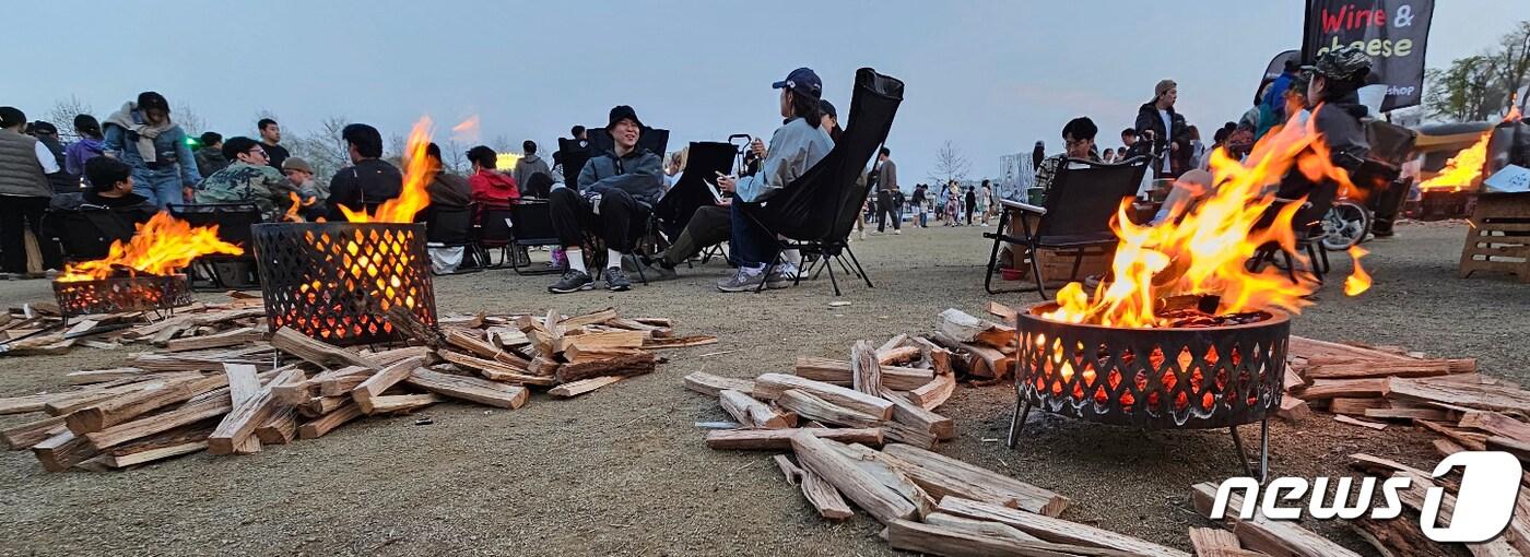 본문 이미지 - 1일 경북 구미낙동강체육공원에서 열린 국내 최대 아웃도어 캠핑축제 '고아웃캠프'에 참여한 캠퍼들이 해가 지자 장작불을 피워놓고 '불멍'을 즐기고 있다. 2023.4.1/뉴스1 ⓒ News1 정우용 기자