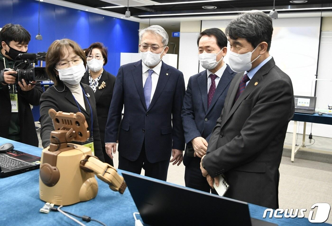 본문 이미지 - 지난해 12월12일 한성대 낙산관 대강당에서 열린 '2022 디지털 새싹 비전 선포식'에서 한성대 조혜경(맨 왼쪽) 교수의 AI 로봇 'MOCCA'시연 장면을 이창원(오른쪽 세번째) 한성대 총장과 이주호(맨 오른쪽) 사회부총리가 지켜보고 있다. (제공=한성대)