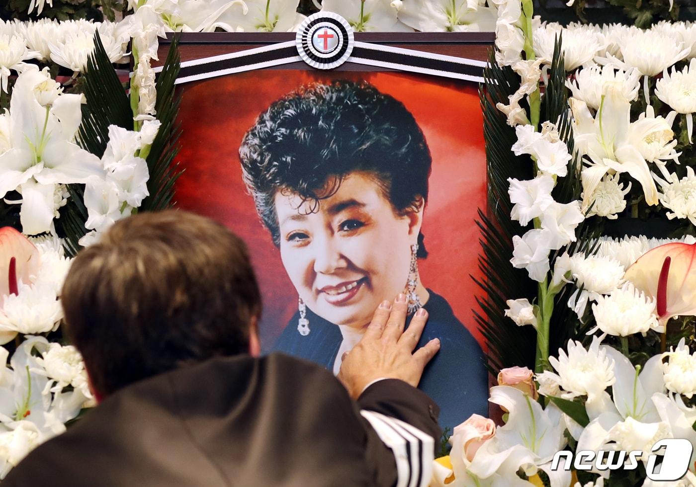 본문 이미지 - 11일 오전 서울 동작구 중앙대학교병원 장례식장에서 엄수된 고(故) 현미의 영결식에서 아들 이영곤 씨가 고인의 영정을 만지고 있다. (공동취재) 2023.4.11/뉴스1 ⓒ News1 권현진 기자