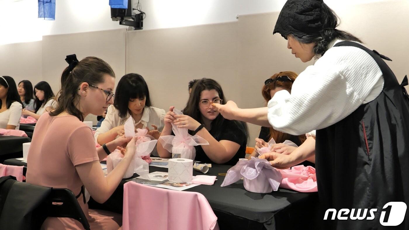본문 이미지 - 충북 청주공예비엔날레 조직위원회 해외 홍보단이 10일(현지시각) 스페인 마드리드 스페인공예진흥원에서 현지인을 대상으로 보자기 체험을 진행하는 등 청주공예비엔날레 홍보에 열을 올리고 있다.(청주시 제공).2023.4.11/뉴스1
