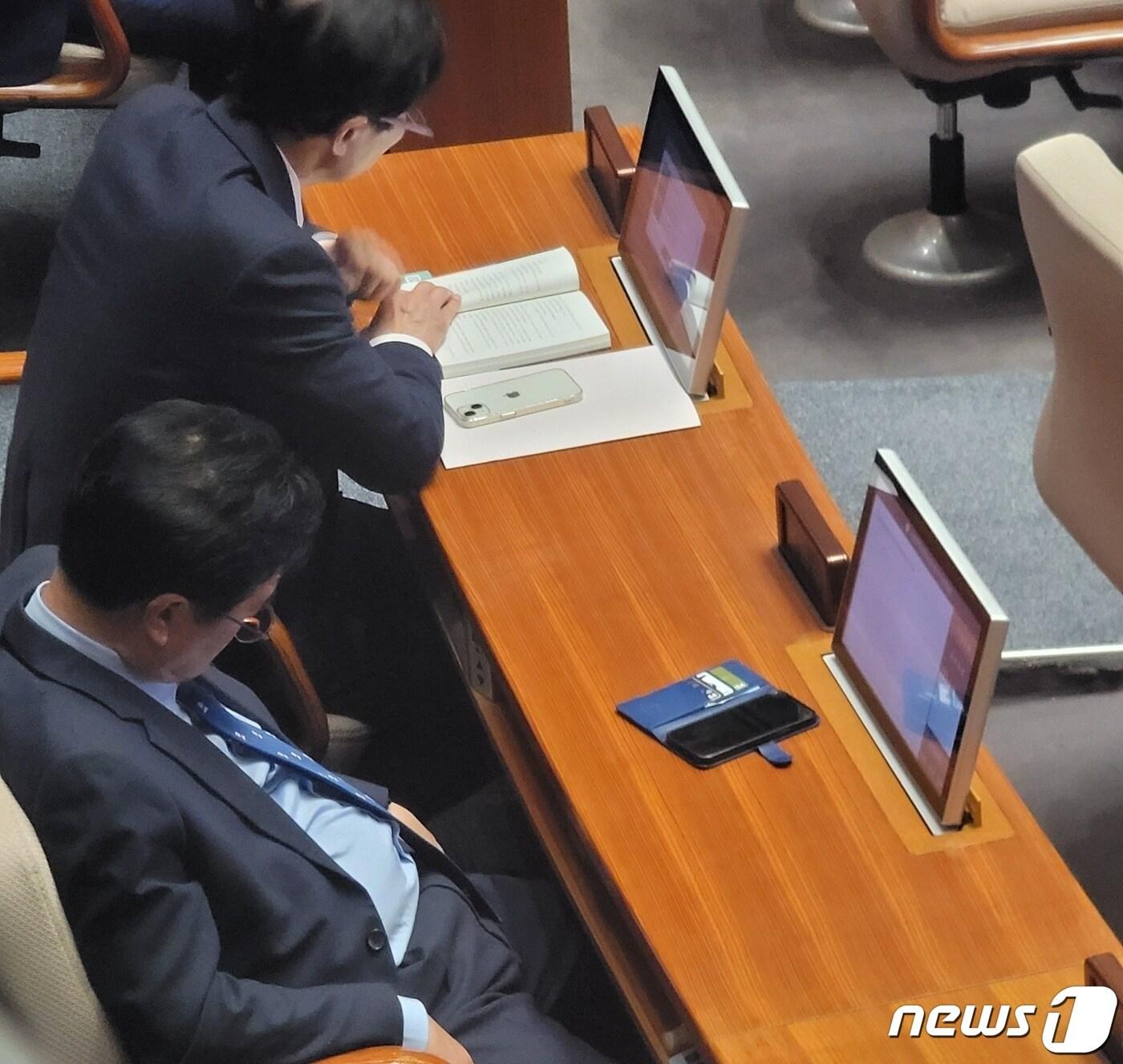 본문 이미지 - 지난 10일 국회 전원위원회에 참석한 의원들이 졸거나 책을 읽고 있다./2023.4.11