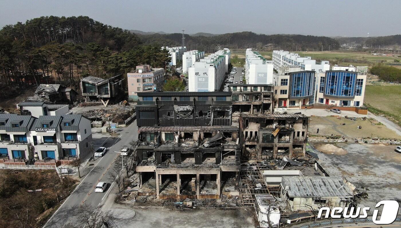 본문 이미지 - 12일 오전 강원도 강릉시 경포로 경포호 인근 펜션단지가 전날 발생한 강릉 산불 화재로 전소돼있다. 바로 뒤로 아파트단지가 보인다. 지난 11일 오전 8시22분쯤 강릉 난곡동 일원에서 산불이 발생했다. 강풍에 산불이 번지자 소방당국은 소방대응 3단계를 발령하고 최고 수위 대응에 나서 8시간만에 진화했다. 이번 산불로 '축구장 530개 면적' 산림을 태우고 주택, 펜션 등 총 100곳이 넘는 시설물이 소실되거나 부분 소실됐으며 1명이 사망했다. 2023.4.12/뉴스1 ⓒ News1 박세연 기자