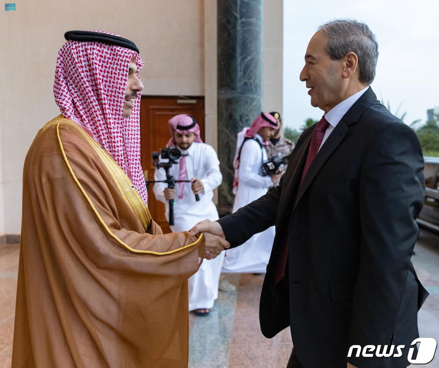 본문 이미지 - 파이살 빈 파르한 알사우드 사우디아라비아 외교장관이 12일 (현지시간) 제다를 방문한 파이잘 메크다드 시리아 외무장관과 만나 악수를 하고 있다. ⓒ AFP=뉴스1 ⓒ News1 우동명 기자