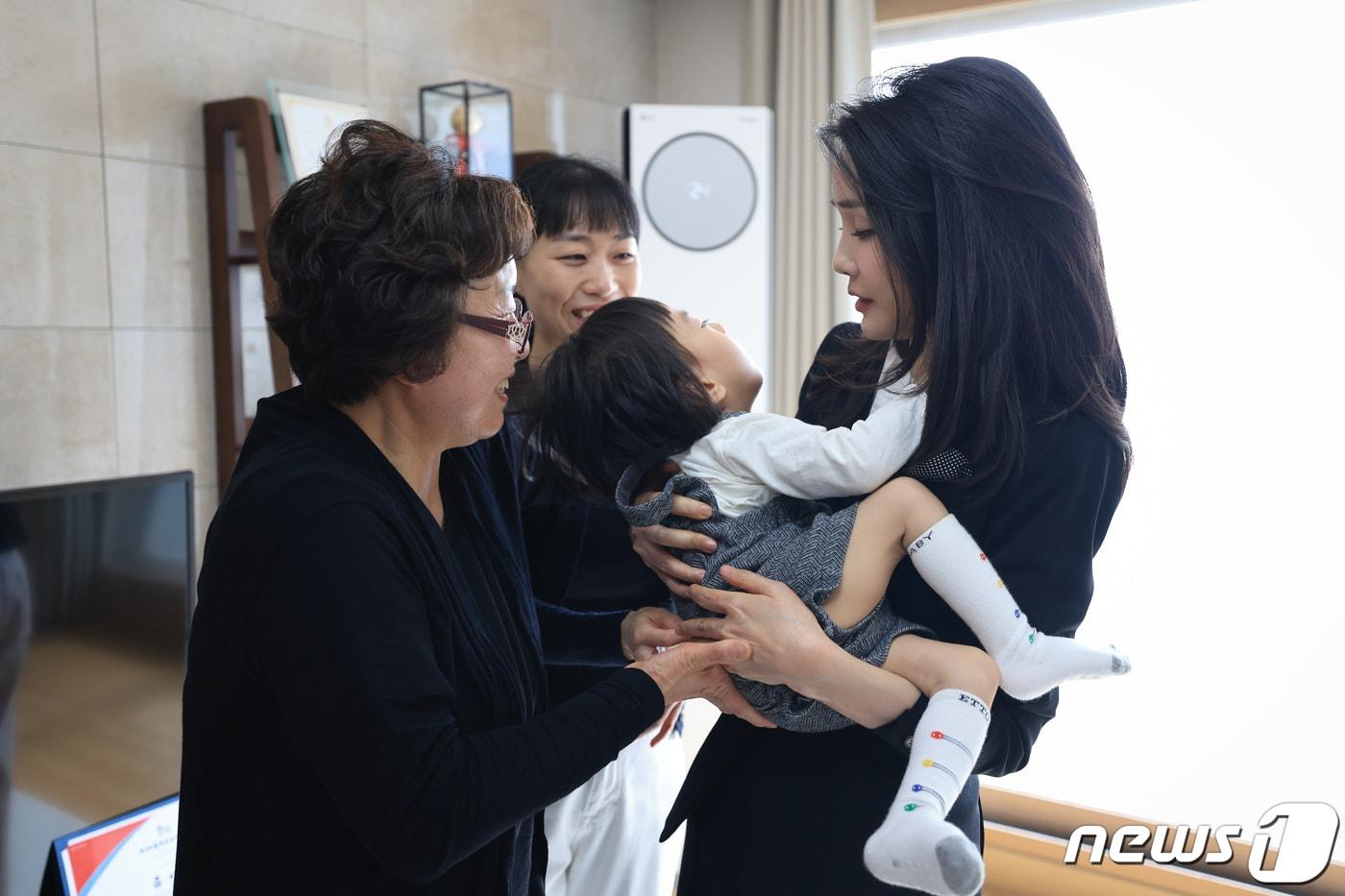 김건희 여사가 13일 3년 전 한강 투신자 수색 중 순직한 고(故) 유재국 경위의 자택을 찾아 아들 이현군을 안고있다. (대통령실 제공) 2023.4.13/뉴스1 ⓒ News1 안은나 기자