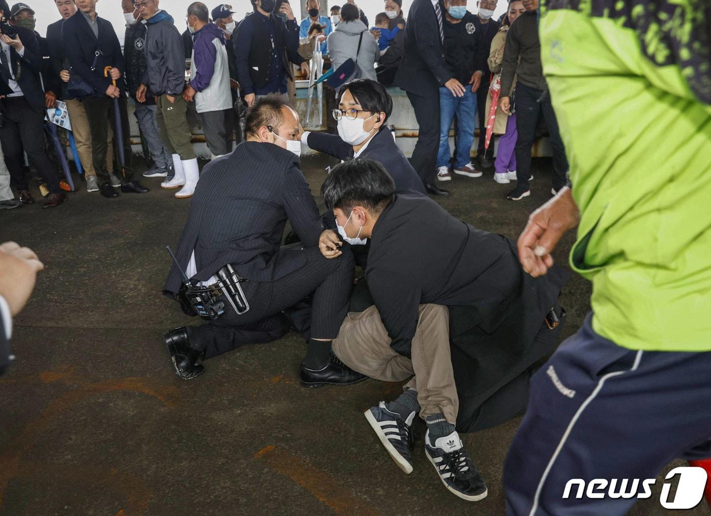본문 이미지 - 기시다 후미오 일본 총리가 중의원(하원) 보궐선거 지원 연설을 위해 방문한 행사장에서 폭발음이 발생했다. 기시다 총리는 15일 오전 11시30분쯤 와카야마현 와카야마시 1구 보궐선거 지원 연설을 위해 행사장을 방문했다. 이때 한 남성이 연설대를 향해 통 모양의 물체를 던졌고, 곧이어 통이 폭발해 흰 연기가 피어올랐다. 연기와 함께 불꽃이 튀고 폭발음이 들렸다는 목격자들의 발언도 이어졌다. 사진은 이날 오전 폭발물로 추정되는 물체를 던진 남성이 경찰에 체포되는 모습. ⓒ 로이터=뉴스1