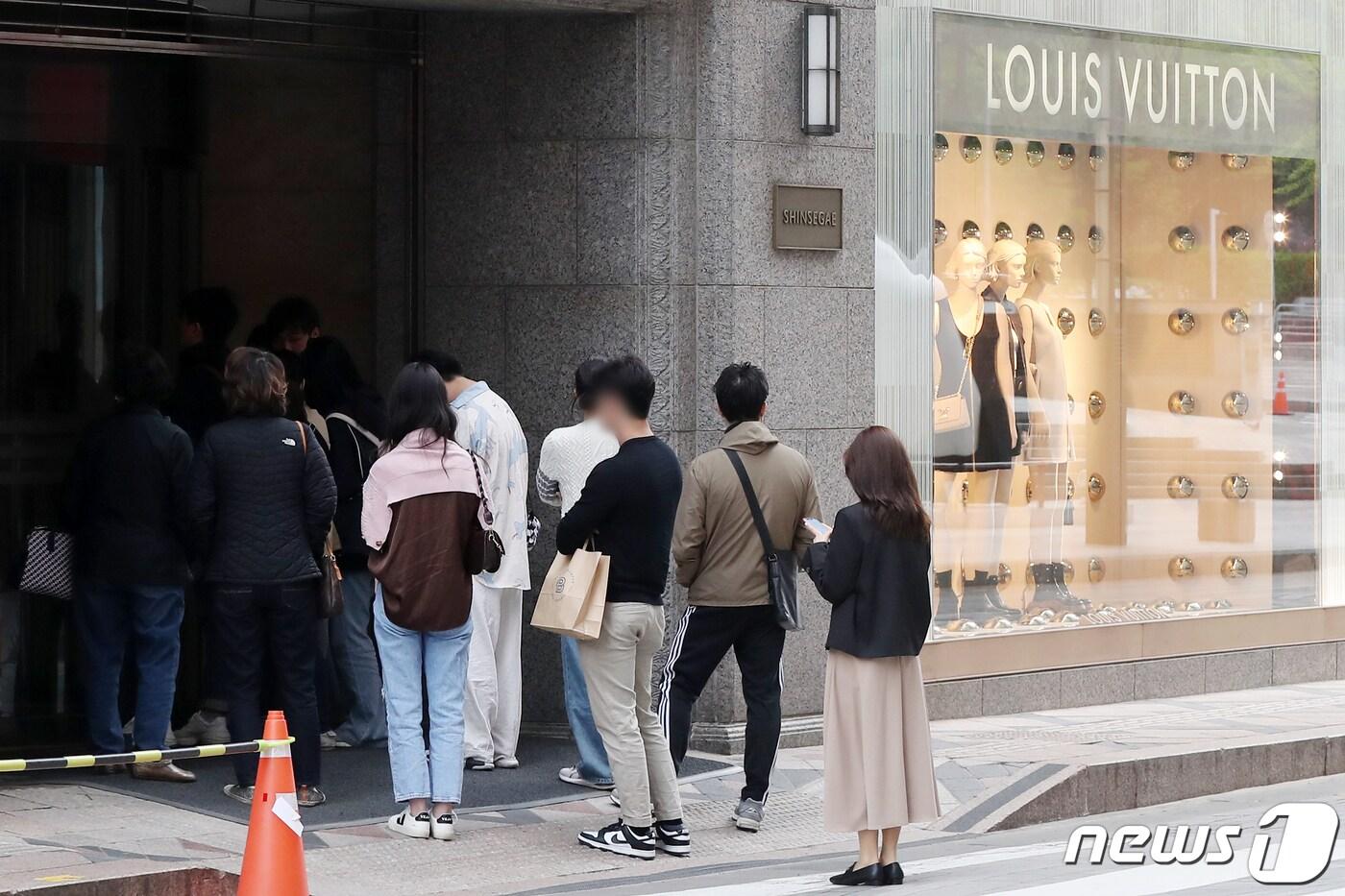 서울의 한 백화점 명품관 앞에서 고객들이 입장 순서를 기다리며 길게 줄을 서 있다. 2023.4.16/뉴스1 ⓒ News1 민경석 기자