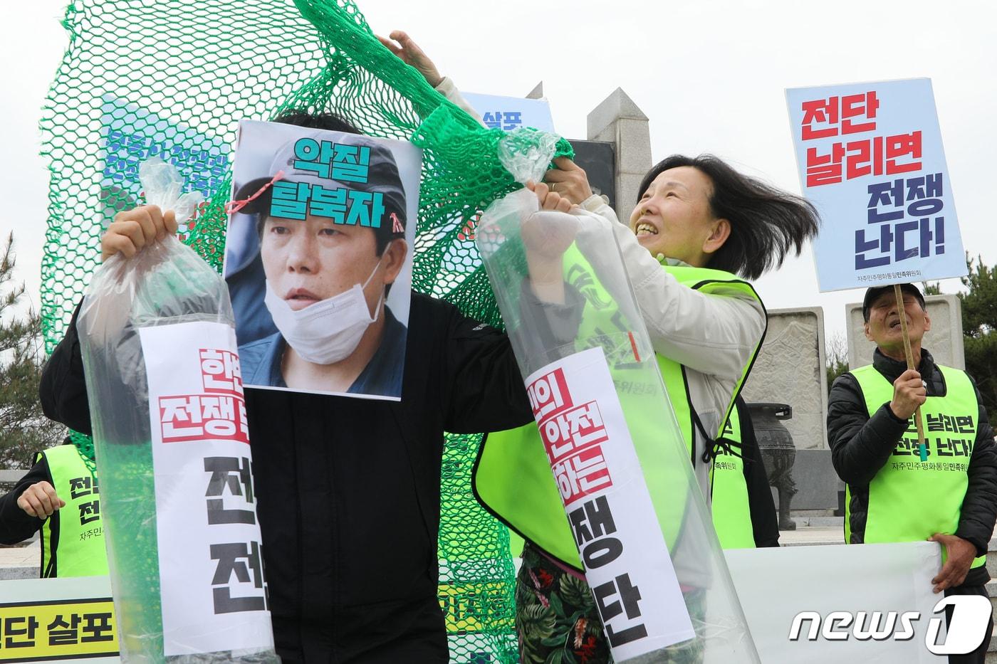 본문 이미지 - 자주민주평화통일민족위원회 회원들이 17일 경기 파주시 임진각 망배단 앞에서 열린 '대북 전단 살포 저지 감시단 활동 돌입 기자회견'에서 드론 전단살포 계획을 밝힌 박상학 자유북한운동연합 대표에게 그물을 씌우는 퍼포먼스를 하고 있다. 2023.4.17/뉴스1 ⓒ News1 안은나 기자